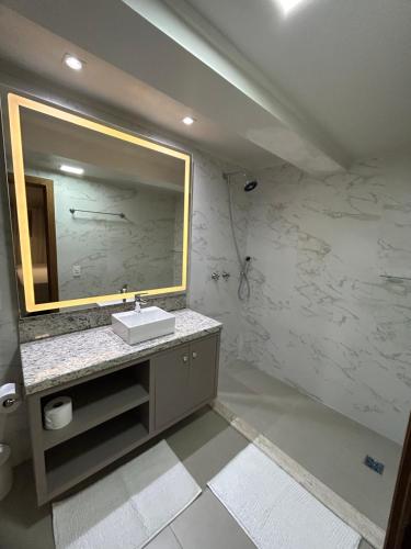 a bathroom with a sink and a mirror at Pousada Villa Verde in Canela