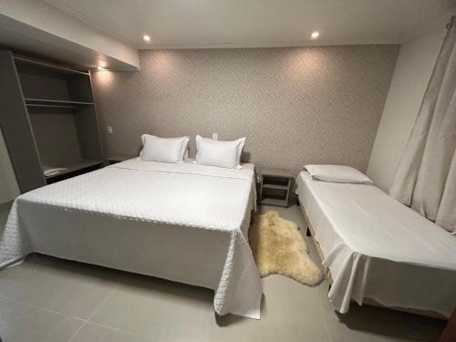 a bedroom with two beds and a stuffed animal on the floor at Pousada Villa Verde in Canela