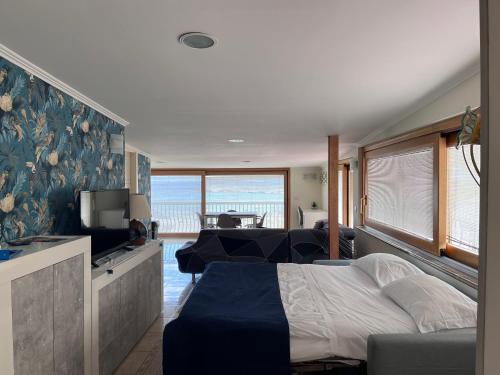 a bedroom with a bed and a couch and a tv at Kalaskiso' in Giardini Naxos