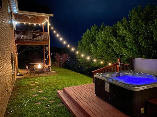 a hot tub on a deck at night with lights at 4BR Walk-in - Foosball Table - Fire Pit - FREE TICKETS INCLUDED - DV166 in Branson