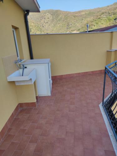 balcón con fregadero y suelo de baldosa en Cottage Gole Alcantara holiday Pafumi, en Graniti