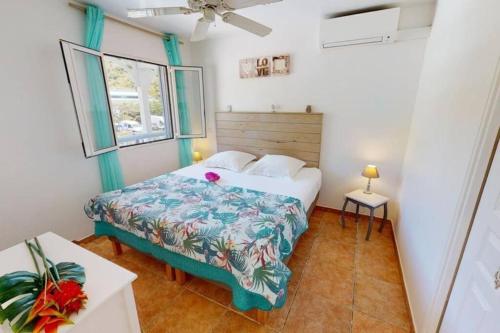 a small bedroom with a bed and a window at Seadream Paradise appartement vue piscine à 150m de la plage in Saint Martin