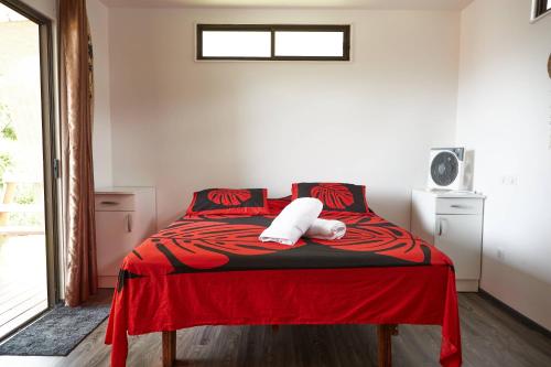 1 dormitorio con 1 cama con manta roja en Le dauphin de te ava iti en Matiti