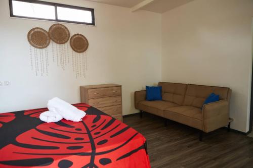 een slaapkamer met een bed en een bank bij Le dauphin de te ava iti in Matiti