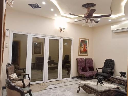 uma sala de estar com cadeiras e uma ventoinha de tecto em White Lotus Corporate Business Boutique em Karachi