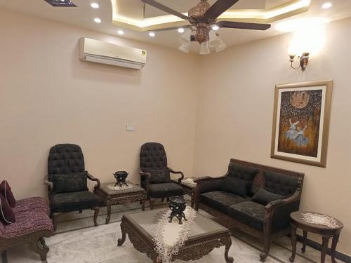 a living room with furniture and a ceiling fan at White Lotus Corporate Business Boutique in Karachi
