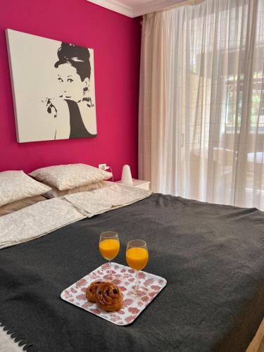 a bed with two glasses of orange juice and donuts at Olivia SunSet Uno in Puerto de Santiago