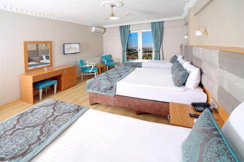 イスタンブールにあるIstanbul Panorama Hotelのベッド2台とデスクが備わるホテルルームです。