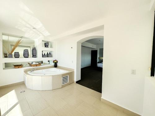 1 dormitorio y baño blanco con bañera. en Hotel Stadium en León