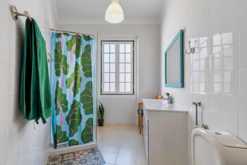 a bathroom with a shower curtain and a sink at A Casa Amarela de Sintra in Sintra