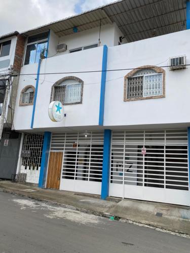 - un bâtiment blanc avec portes et fenêtres donnant sur une rue dans l'établissement Playa Aparts & Suites Malecon, à Manta