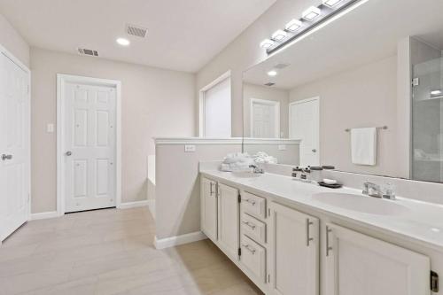 Baño blanco con 2 lavabos y espejo grande en Your Home Away from Home in Austin!, en Austin