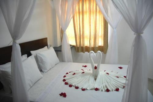 a bedroom with a white bed with roses on it at Romântico com vista deslumbrante in Natal