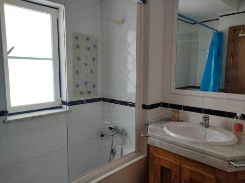 a bathroom with a shower and a sink and a mirror at Casa Guerreiro in Longueira