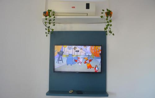 a tv in a wall with a cartoon on it at Apto Romântico frente mar vista mar Elegance Flat in Natal