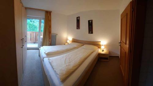 a bedroom with a large bed with two lights on it at Ferienwohnungen Bachbauer in Weyregg