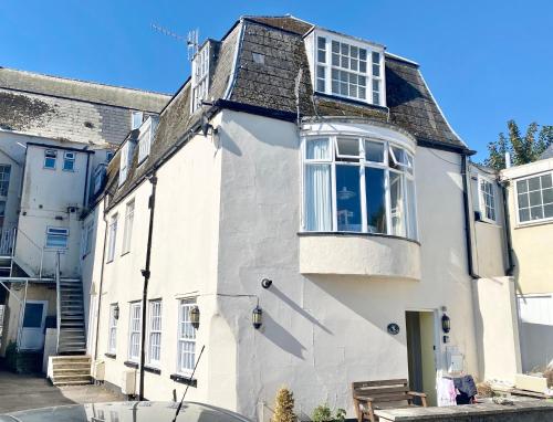 a white house with a window on the side of it at Jasper Apartment in Lyme Regis