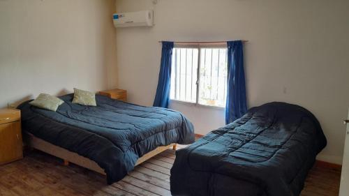 a bedroom with two beds and a window at Duplex en el centro de Concepción del Uruguay in Concepción del Uruguay