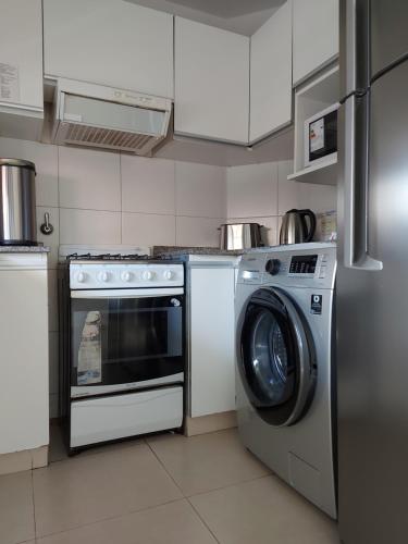 a kitchen with a stove and a washing machine at Lo que buscabas en Nueva Cordoba in Córdoba