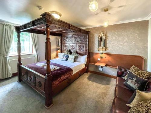 a bedroom with a canopy bed and a couch at Dalgarven Spa House in Dalry
