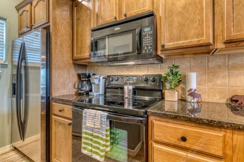 a kitchen with a stove and a microwave at 2BR Condo - Dock for Fishing - Jacuzzi Tub - FREE TICKETS INCLUDED - MJ4-130 in Branson