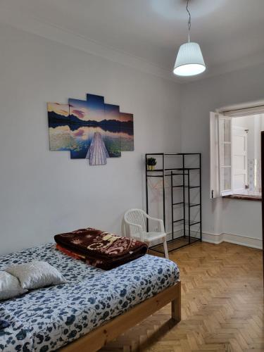 a bedroom with a bed and a painting on the wall at Rainbow Guest House in Lisbon