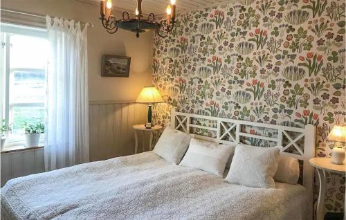 a bedroom with a white bed with a floral wallpaper at Nice Home In stn With House Sea View 