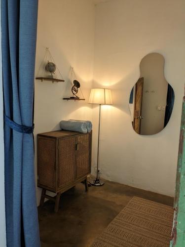 a room with a lamp and a mirror on the wall at La Veranda Hotel & Restaurant in Minca