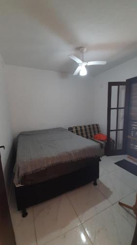 1 dormitorio con 1 cama y ventilador de techo en Apto Peró Cabo Frio 700m da Praia, en Cabo Frío