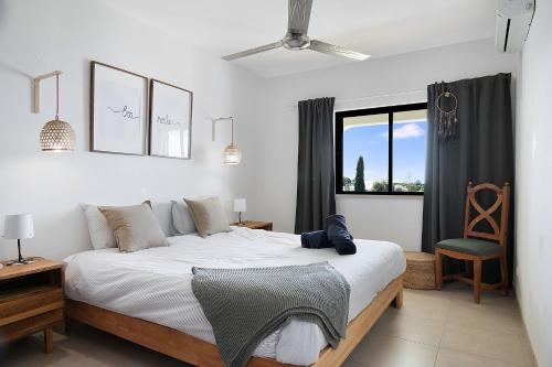 ein Schlafzimmer mit einem großen weißen Bett und einem Fenster in der Unterkunft Carvoeiro -Spacious 2 bedroom appartment with pool - Monte Dourado in Carvoeiro