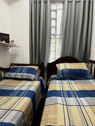 a bedroom with two beds and a window at Cantinho do Thiê in Paquetá