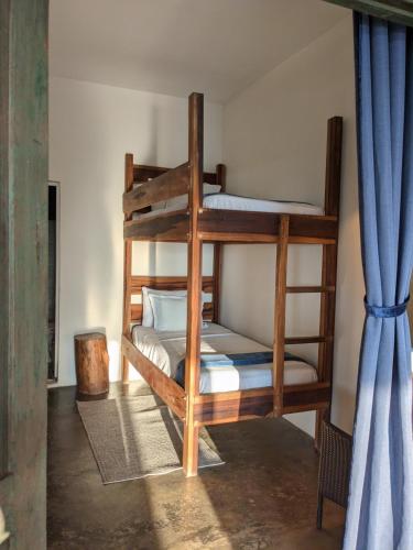 two bunk beds in a room with a blue curtain at La Veranda Hotel & Restaurant in Minca