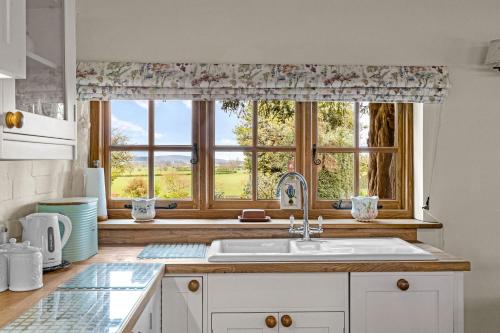une cuisine avec un évier et une fenêtre dans l'établissement Gardeners Cottage near Ledbury, à Ledbury