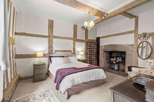a bedroom with a bed and a fireplace at Gardeners Cottage near Ledbury in Ledbury