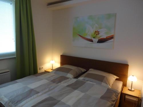 - une chambre avec un lit avec deux lampes et un tableau dans l'établissement TER-101-Terrassenhuegel-Teilseeblick, à Scharbeutz