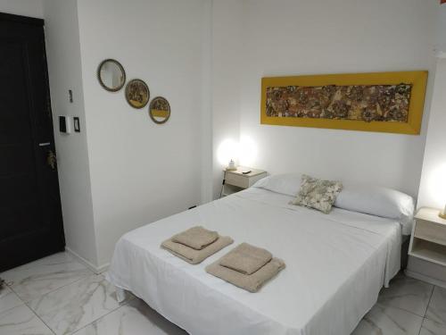 une chambre avec un lit blanc avec des serviettes dessus dans l'établissement Tres Fronteras Apart 2, à Puerto Iguazú