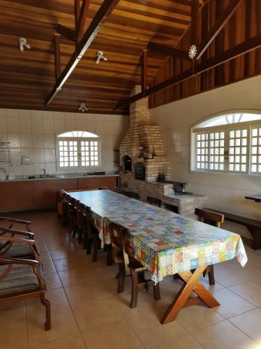 uma grande cozinha com uma grande mesa e cadeiras em Casa do Nonno na Montanha em Campos do Jordão