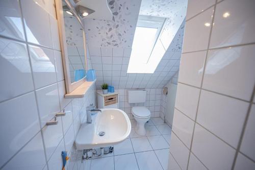 a white bathroom with a sink and a toilet at Wohnung-Ley in Dahme