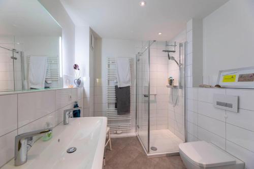 La salle de bains est pourvue d'une douche, de toilettes et d'un lavabo. dans l'établissement Strandhafer-Wulf-Weber, à Hohwacht
