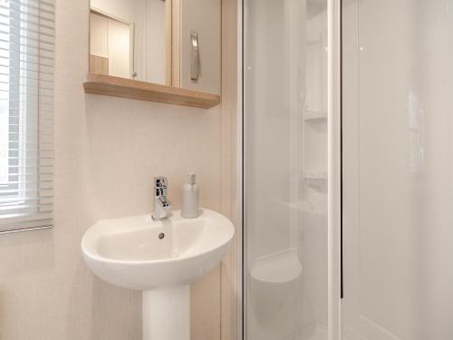 y baño con lavabo y ducha. en Uk43577 - Oakdale, en Begelly