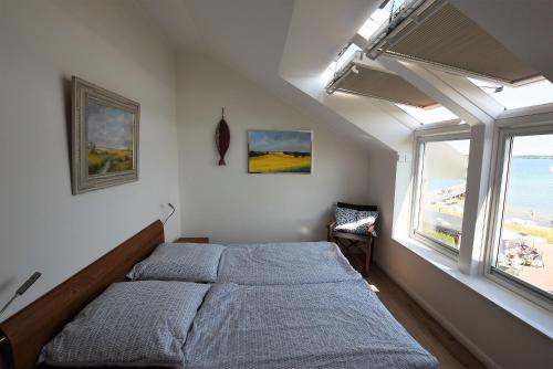 a bedroom with a bed and a large window at Meeresblick-Deck-44-Haus-3-WE-44 in Hohwacht