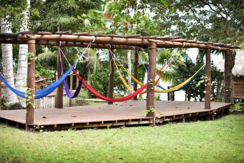 a swing with colorful ropes on a wooden deck at Hotel Rancho Encantado in Bacalar