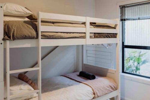 a bedroom with bunk beds in a room with a window at Beach Haven Scamander in Scamander