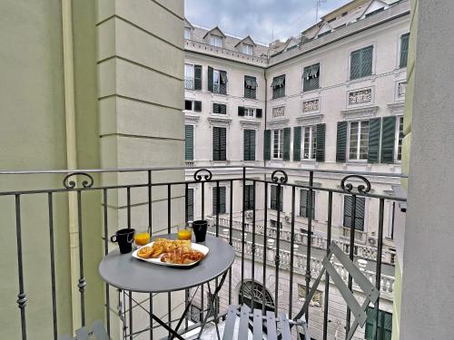 una mesa con un plato de comida en el balcón en Happy Family Apartments U Papaviou, en Génova