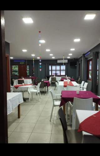 a dining room with white tables and white chairs at Alpha & Omega Apartment Seychelles in Beau Vallon