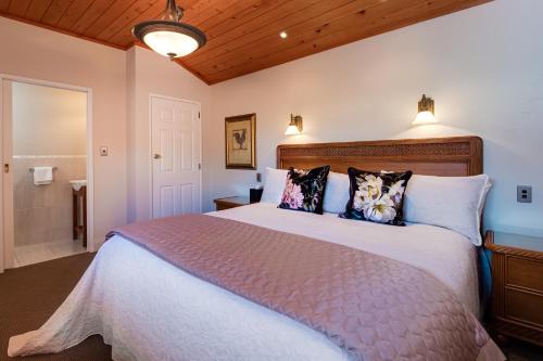 a bedroom with a large white bed with pillows at On The Point - Lake Rotorua in Rotorua