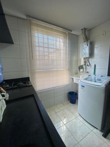 a small kitchen with a refrigerator and a sink at Residencial Cayenne in Caxias do Sul