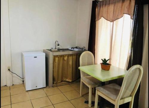 cocina pequeña con mesa y nevera pequeña en Apartamentos Zamora, en Puerto Limón