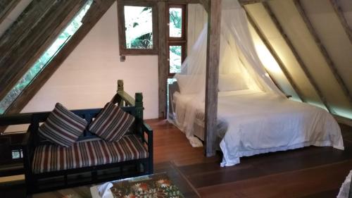 a bedroom with a bed and a couch in a room at Mi Casa - The gem of Ijen in Banyuwangi