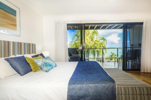 a bedroom with a bed with a view of the ocean at Shorelines 23 On Hamilton Island in Hamilton Island